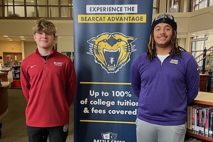 Noah Nichols, at left, and DeVoine Newton, Jr., at right, strike a pose during a media event at Battle Creek Central High School.