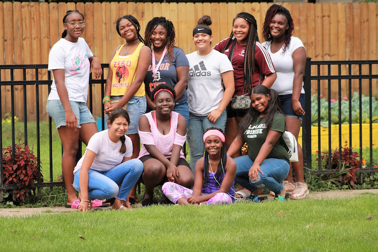 Participants in the Kalamazoo Junior Girls Organization camp take a moment from gardening