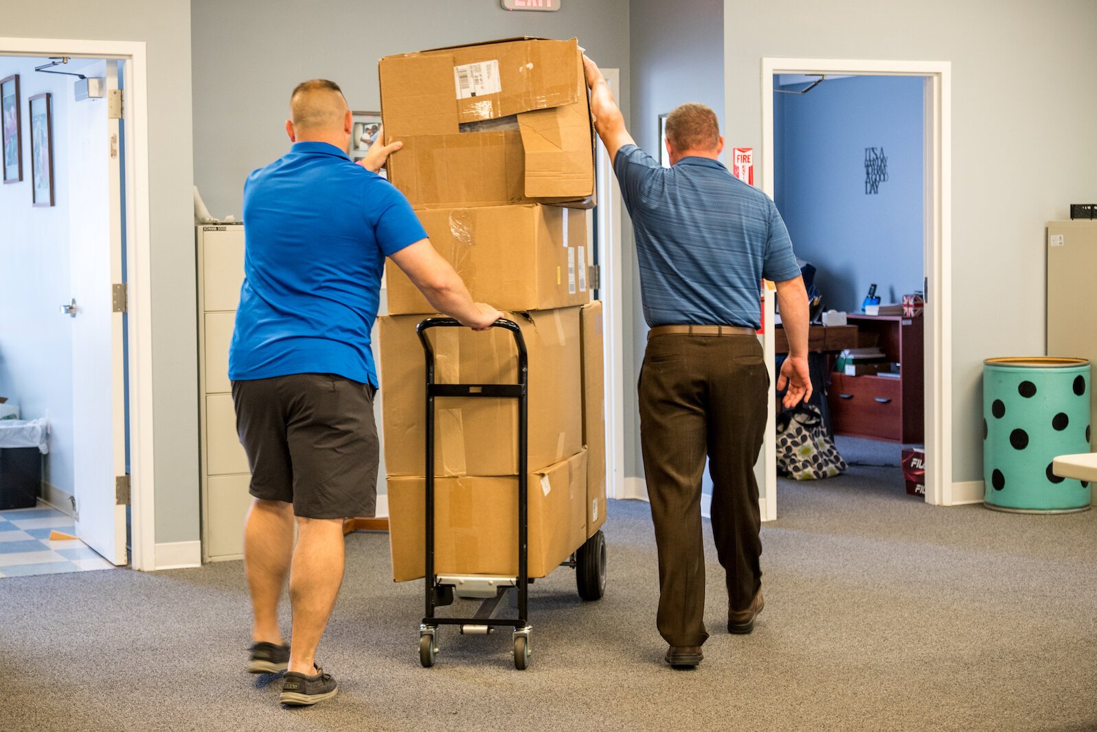 Don Solesbee, left, and Cody Livingston, of Guys Who Give, transport boxes on Wednesday, June 22, 2022, to be recycled from First Day Shoe Fund.
