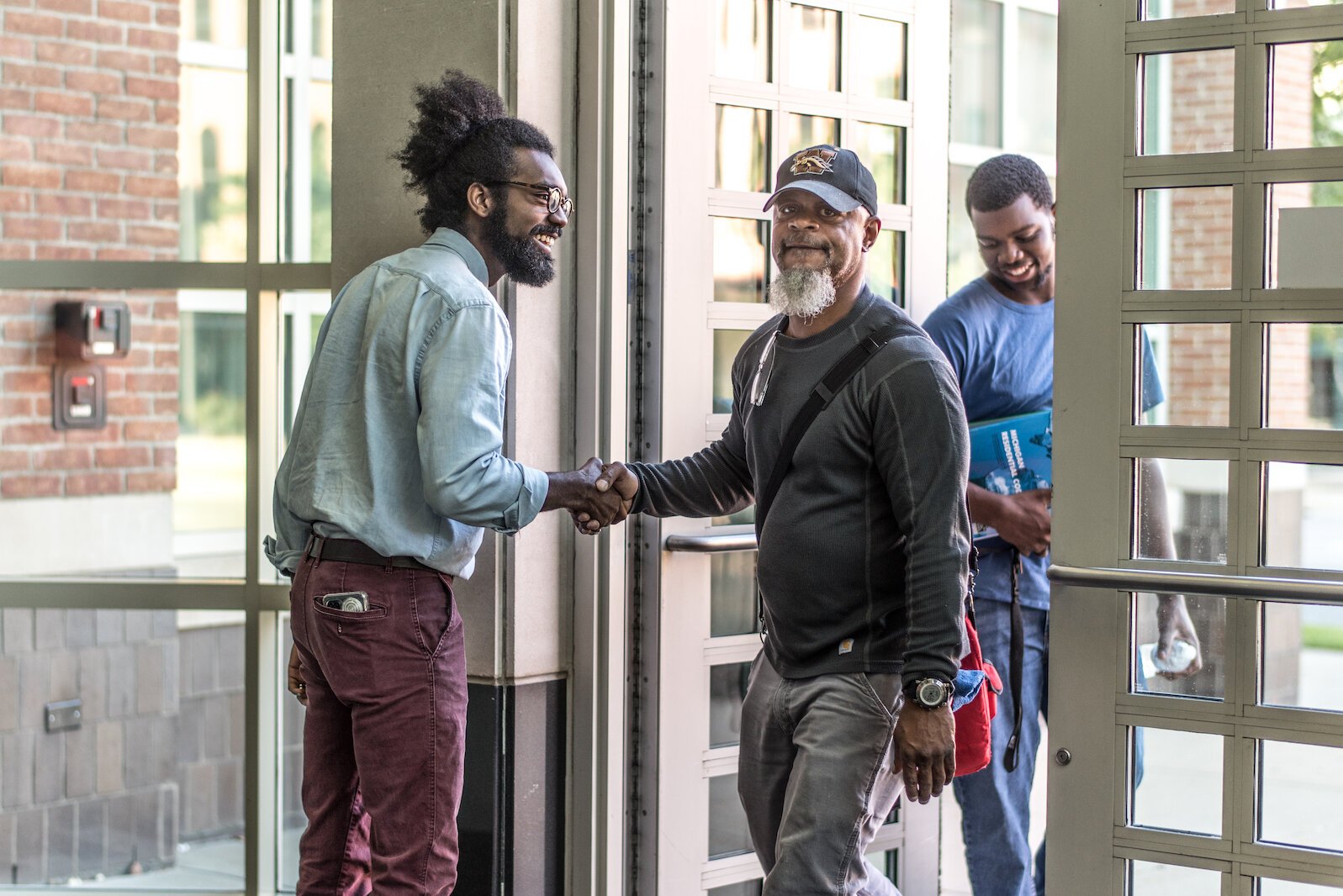  Joshua Gray, chief operating office of small business consulting firm Room 35,  greets Anthony Hunter and other participants in Core 60, a training program for those who intend to pass the Michigan Builders License Examination.
