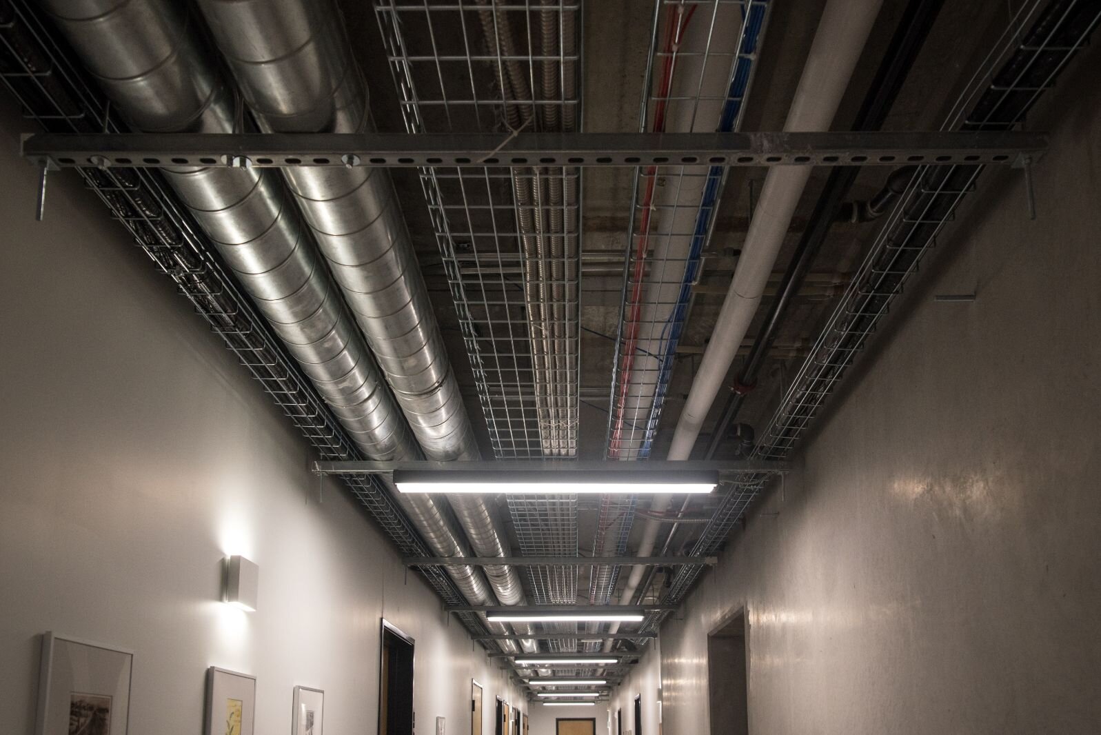 Precast concrete floors and walls, along with exposed overhead utility pipes, are part of the “industrial modern” interior design of Harrison Circle Apartments.