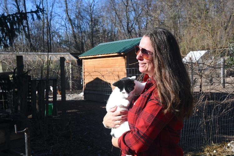 Tawney Wolters holds one of the many cats that roam Fluffy Butt Farms.
