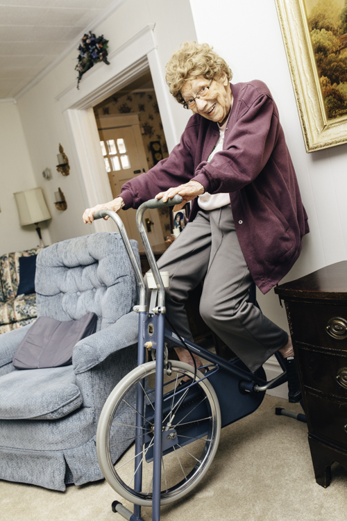 At nearly 102, Gwen Tulk riders her exercise bike while watching the nightly news. She says she'd walk more if there were sidewalks on her street.