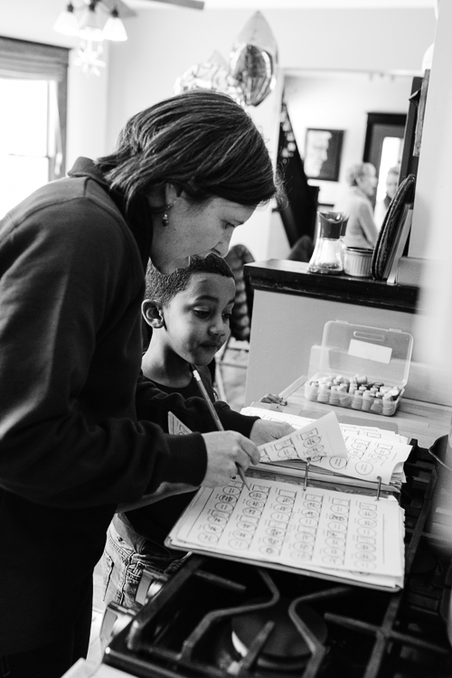 Molly Mechtenberg-Berrigan, one of the Peace House founders, helps a young person with homework.