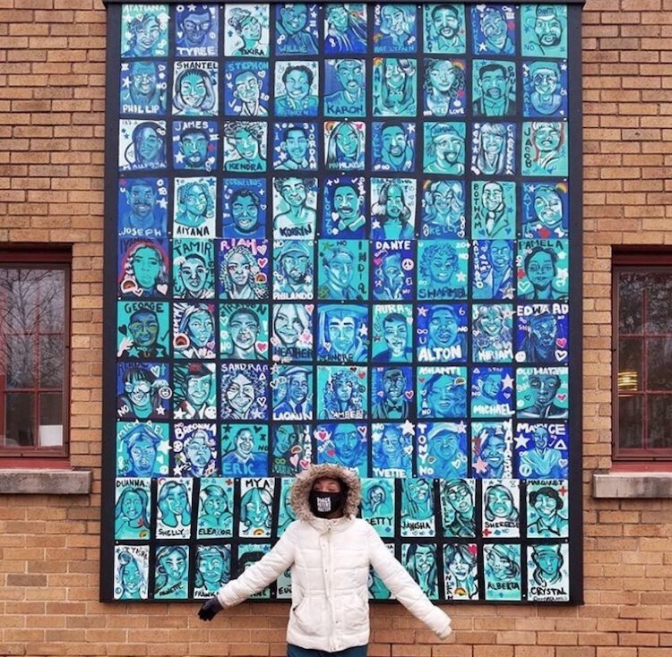 Social Practice Artist Maya James with her first permanent public mural “Faces: Pt I”, which honors 94 victims of police and mob brutality in the past thirty-five years 