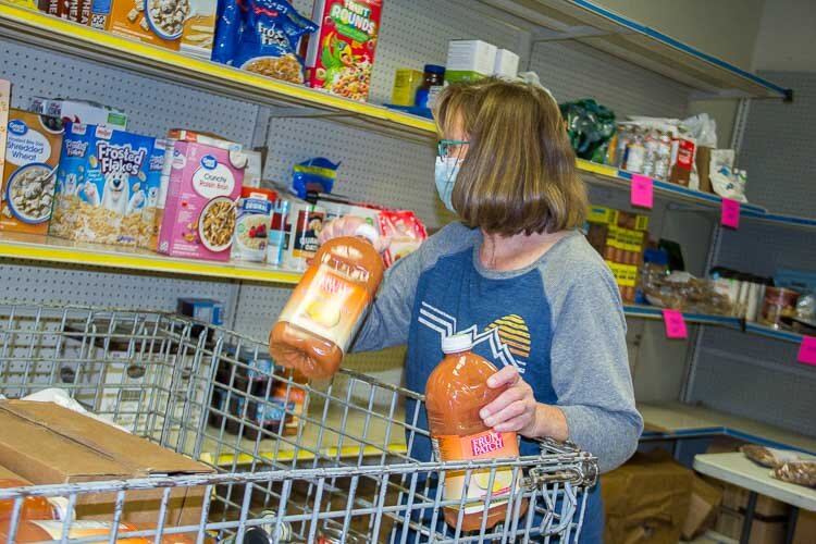 Volunteer Roxanne Frey helps get food donations ready for distribution.