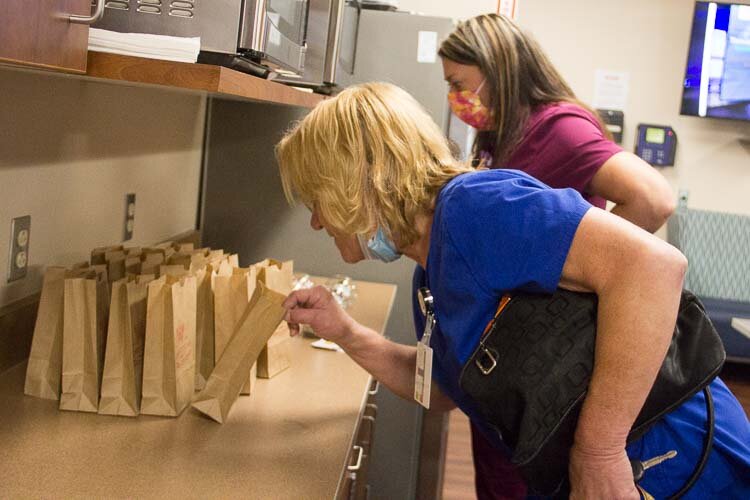 Healthcare workers in the break room at Family Health Center pick out their treat provided by Feed the Fight. 