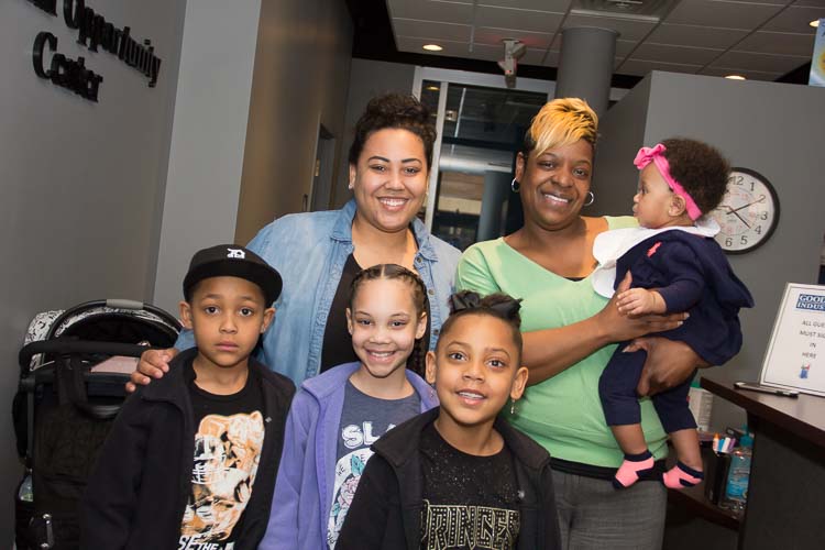 Stephenie Potter with her children, Robert, Kamariona, and RahMya and baby Reighlyn held by Taneka Thomas, Workforce Development Liaison. Photo by Susan Andress