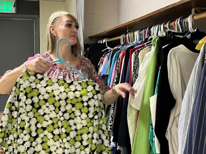  Stephanie McNeil organizes clothing at the Co-op's clothing closet.