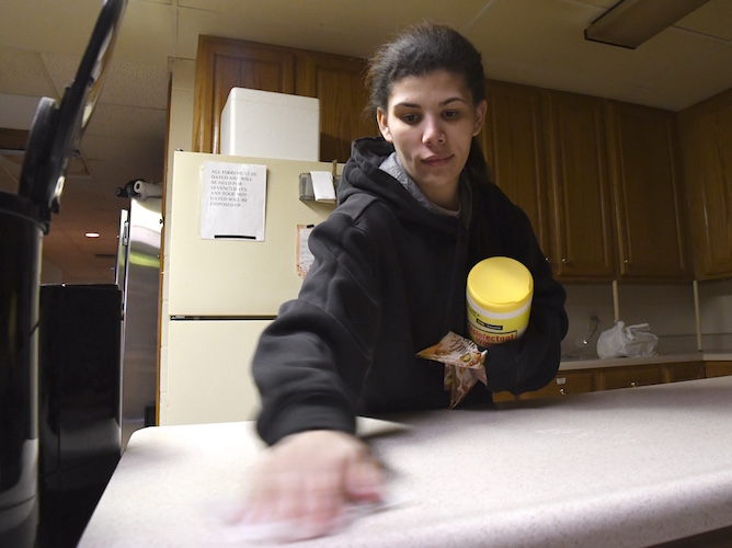 Sabrina Bottom, co-op member, cleans up a kitchen counter.