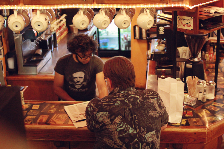 Sadaat Hossain, owner of The Raven Cafe, chats with customer James Childers from Plano, TX.