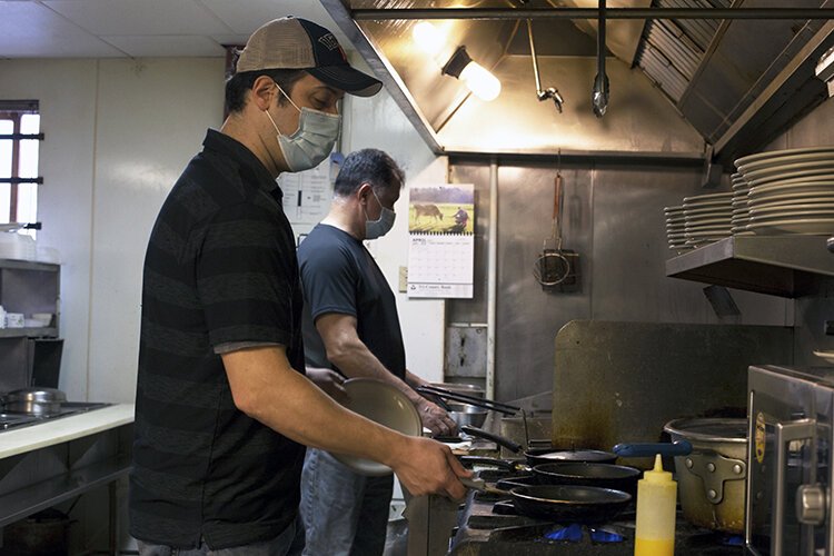 General Manager of Louie's Family Restaurant, Jason Dimoski (left), and his father and founder of the establishment, Louie Dimoski, work together in the kitchen to prepare breakfast for diners.