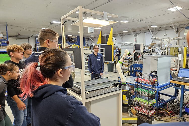 Yale High School students watch a robot sort soda during a demonstration at Blue Water Controls on Manufacturing Day in 2023.