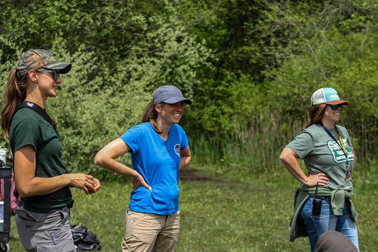 Kaitlyn Barns (left), biologist from the Michigan DNR, Lynnea McFadden (middle) from Friends of the St. Clair River, and Nikki DeGowske (right) talking with students about what they found and their experience during the Bioblitz 2023.