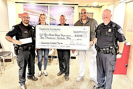 Community Foundation of St. Clair County staff pose for a photo with members of the Port Huron Police Department which received a grant for the department's community outreach trailer.