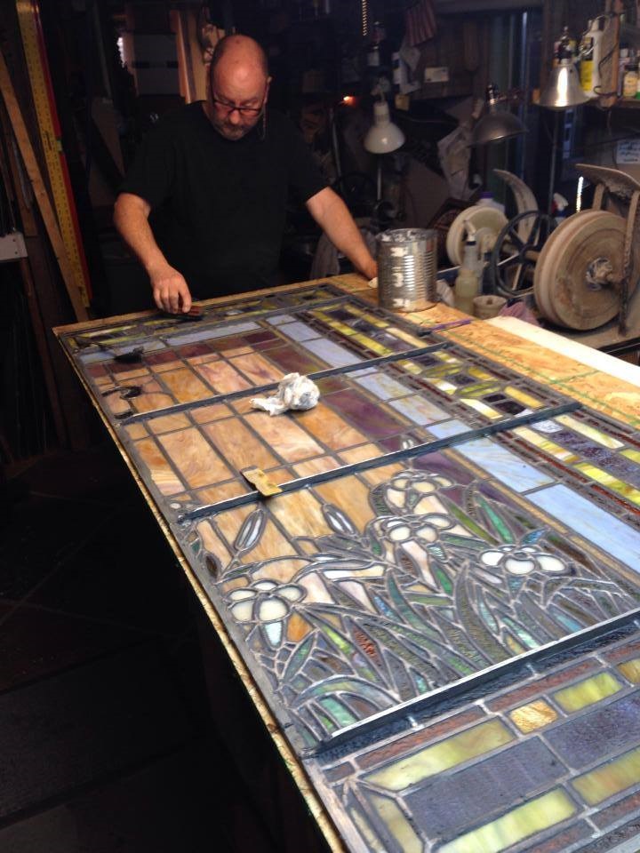 Donny Burton works on restoring a piece of stained glass.