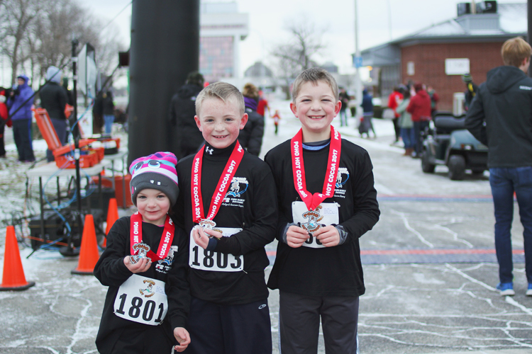 Sibling power! Griffin, Luke, and Finley Badley of Marysville show off the medals they earned for finishing the Kid’s Mile.