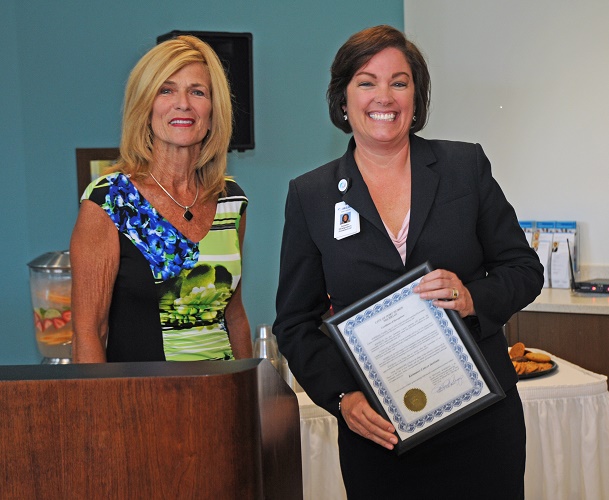 Port Huron Mayor Pauline Repp hands  CEO, Jennifer Montgomery, a proclamation at the ribbon cutting event.  