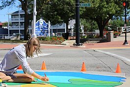 Kayla Faust, a student at Port Huron Northern High School, paints her mural at the corner of Water and Military Street in downtown Port Huron.