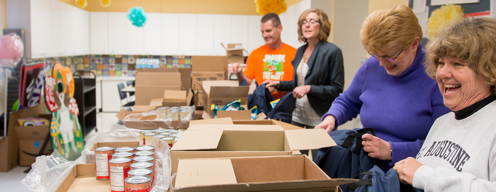 Volunteers prepare backpacks of food to send home with children.