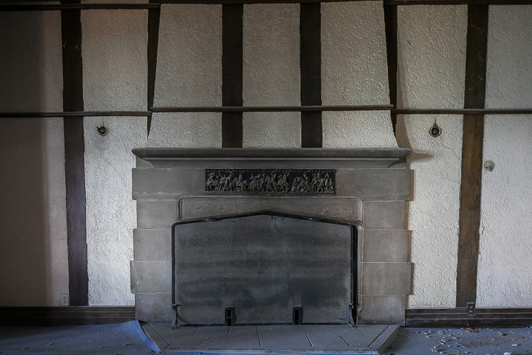 A decorative fireplace awaits its restoration.