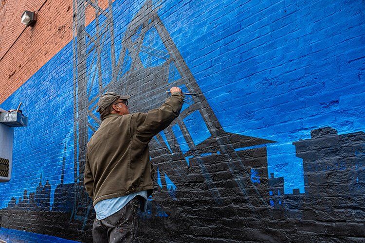 Steve Nordgren works on his mural outside The Active Lounge located on 7th St. in Port Huron, Michigan.