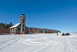 Skiers and snowmobilers enjoy the view at Grand Island East Channel Lighthouse