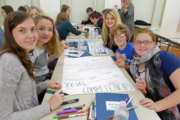 Students from Superior Central Schools write examples of Developmental Assets they see in their community during the Alger County Youth Summit .