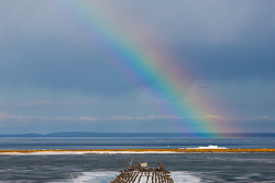 the first rainbow of Spring appears over a thawing Marquette Lower Harbor