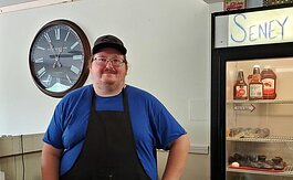Ryan Smith stands behind the counter of his new restaurant, Seney Crossing, in Seney, Mich.  