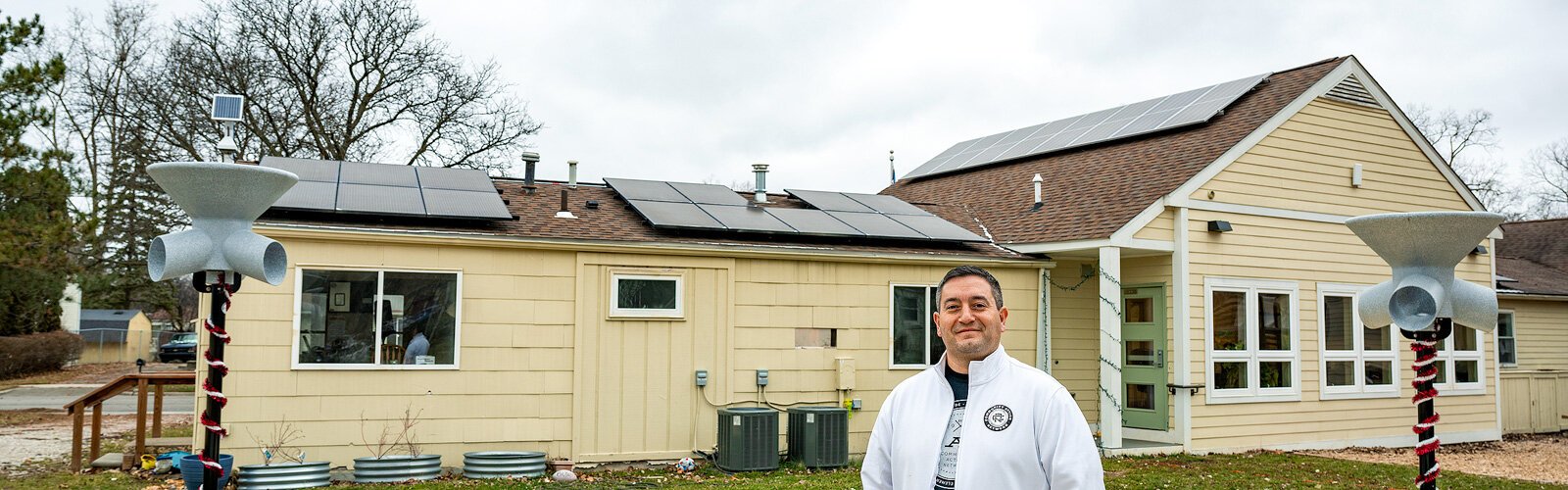 Community Action Network Executive Director Derrick Miller in front of the solar panels on the Bryant Community Center.