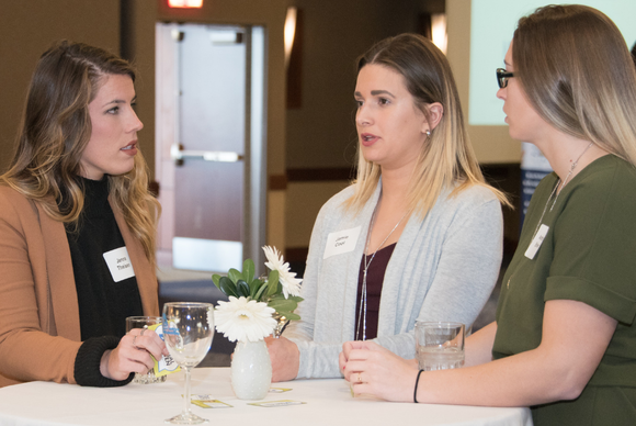 Casual conversations keep the Coming Home event from feeling like a traditional job fair. During the 2018 event, participants gathered at high-top tables.