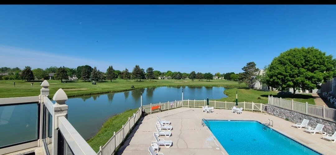 The pool deck overlooks a pond and the golf course. 