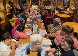 People supported by Blue Water Developmental Housing gather for a birthday dinner at a restaurant