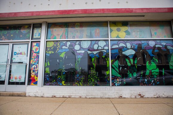 Colorful silhouettes adorn the glass on the front of the Do-Art studio in downtown Bay City.
