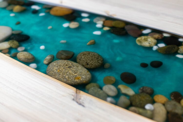 A river runs through the dining table Johnston is working on. Johnston says he will occasionally invite clients in to provide creative insight to their projects, and the client who commissioned this piece placed the rocks within the river. 