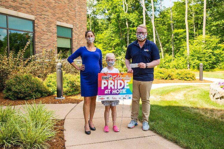 In 2020, the annual Great Lakes Bay Pride Festival turned into an at-home format. Scott Ellis, at right, encouraged people and businesses to display these signs during the festival.