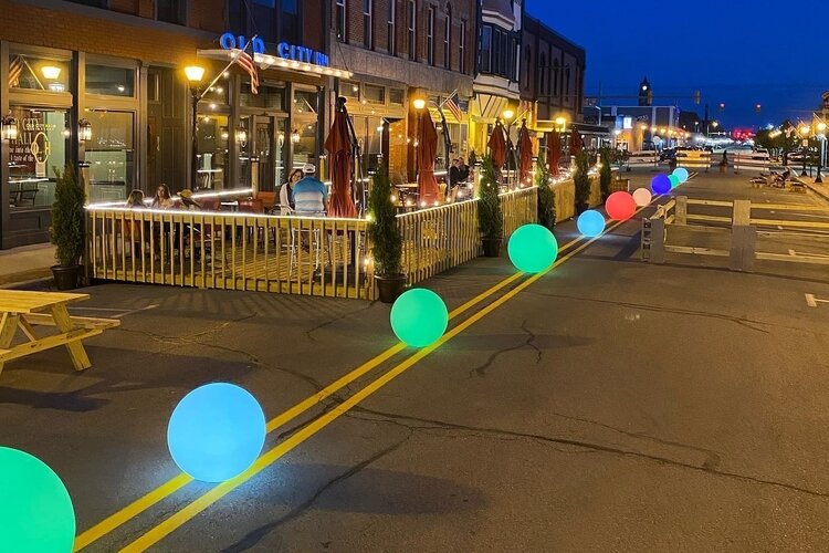 Colorful balls light up Saginaw Street outside several restaurants and coffee shops.