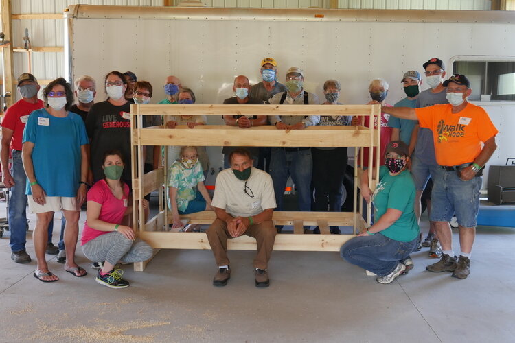 A core group of experienced volunteers and staff from Lowe’s Home Improvement help guide people through building their first bed.