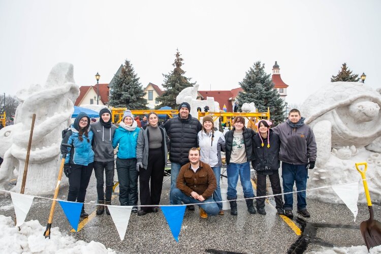 Art teacher Howard McLean poses with the two Bay City Central High School teams at Snowfest 2024.