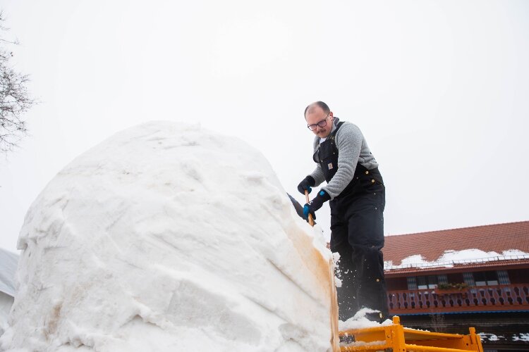 Garrett Weslock climbs a ladder to work on top of the sculpture.