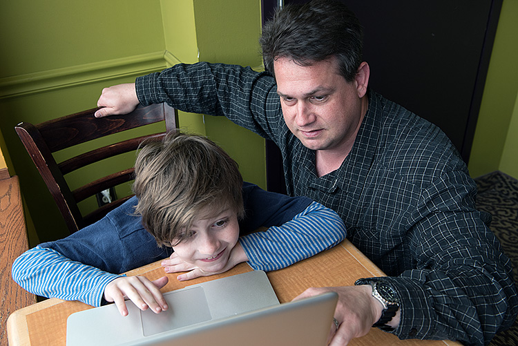 Eli and his father Pat doing school work - Photo Dave Trumpie