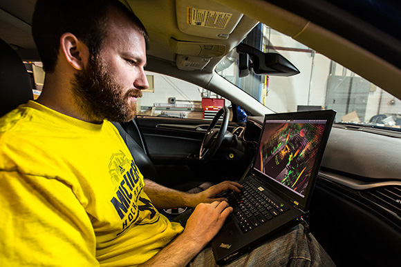 Schuyler Cohen with a Ford Fusion Hybrid Automated Next Generation Vehicle at U of M