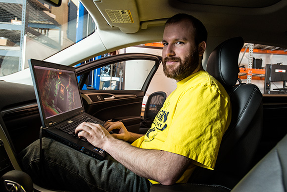 Schuyler Cohen with a Ford Fusion Hybrid Automated Next Generation Vehicle at U of M