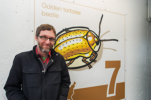 Bruce Worden with one of his art panels at the Maynard Parking Structure in Ann Arbor