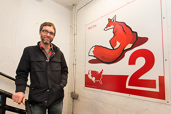 Bruce Worden with one of his art panels at the Maynard Parking Structure in Ann Arbor