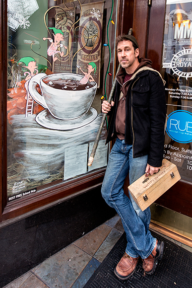 David Zinn with one his holiday window paintings on Main Street