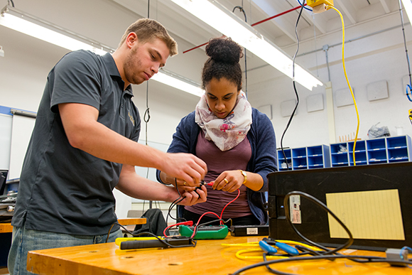 Ryan Dixon helps Sina Webster test a cable