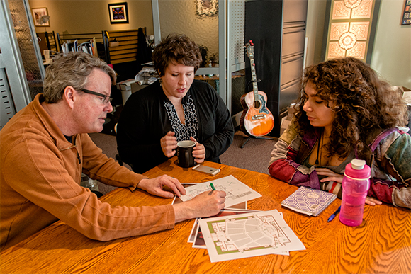 Robert White and Brienne Willcock consult with a coworker at the Illuminart ofice