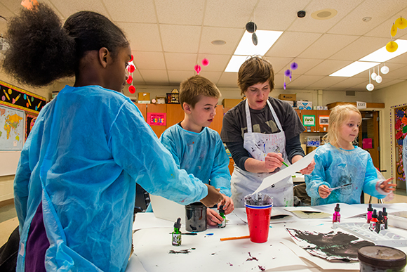 FLY Children's Art Center Director Christine Bruxvoort helping kids with art projects at Erickson Elementary